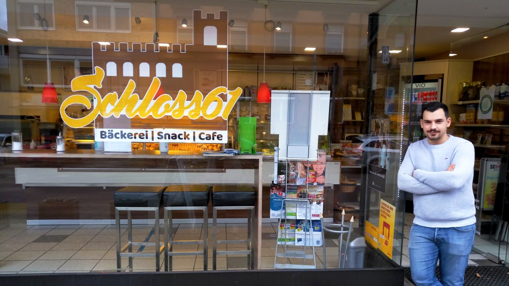 Kerim steht vor seinem Café.